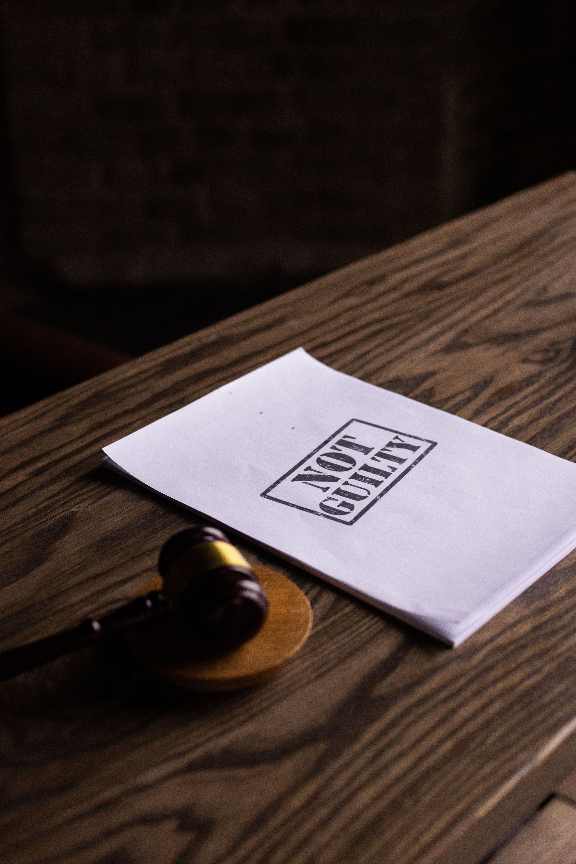 A legal gavel next to a 'Not Guilty' document on a wooden table, symbolizing justice.
