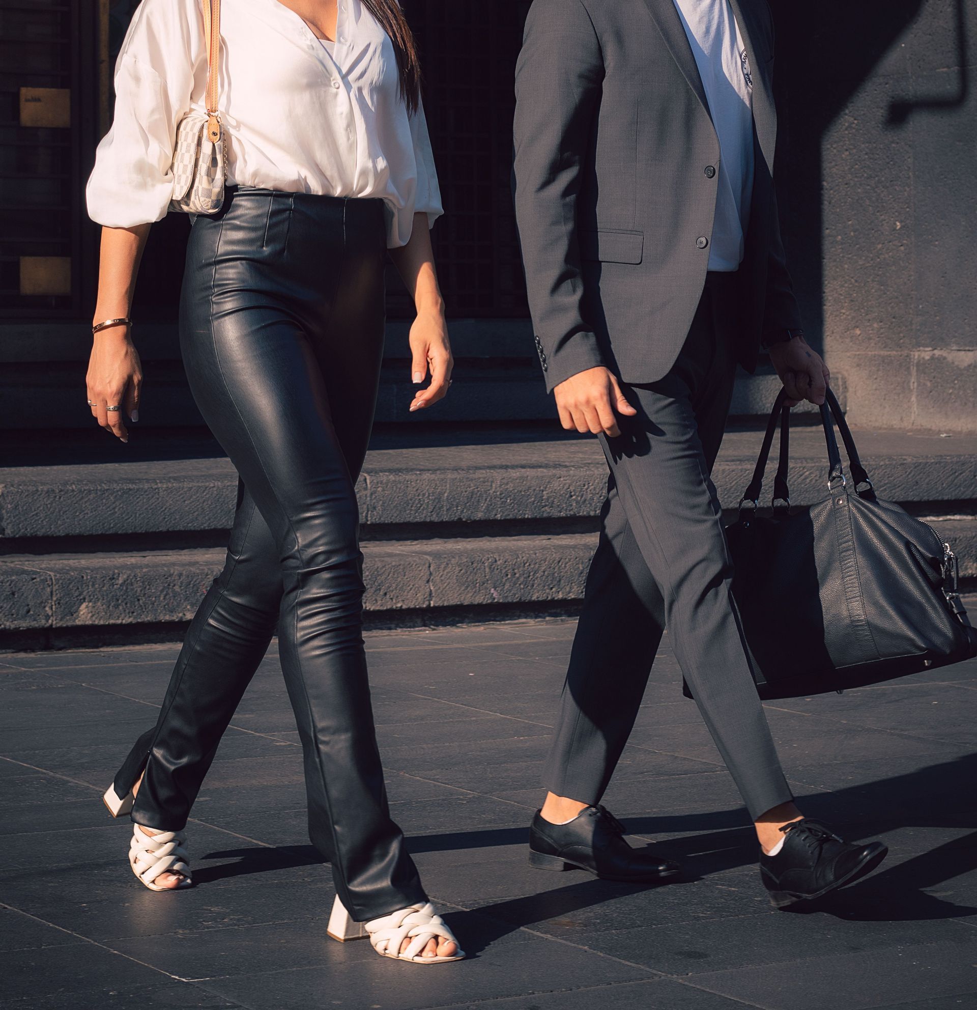 Elegant couple in suits walking outdoors in the sun, Ciudad de México